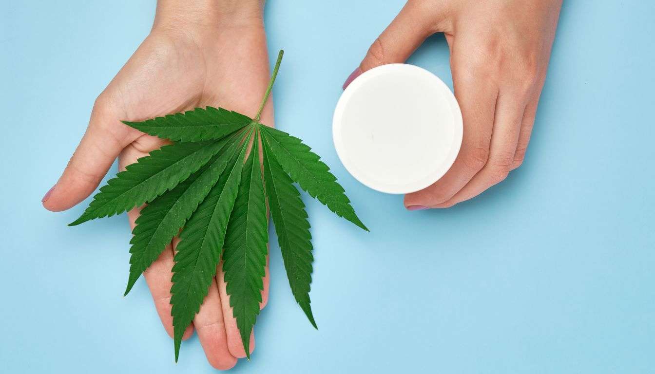 hvid-blank-creme-rør-nær-grønne-cannabis-blade